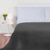 Een bed met een Good Night wollen deken  en witte lakens.
